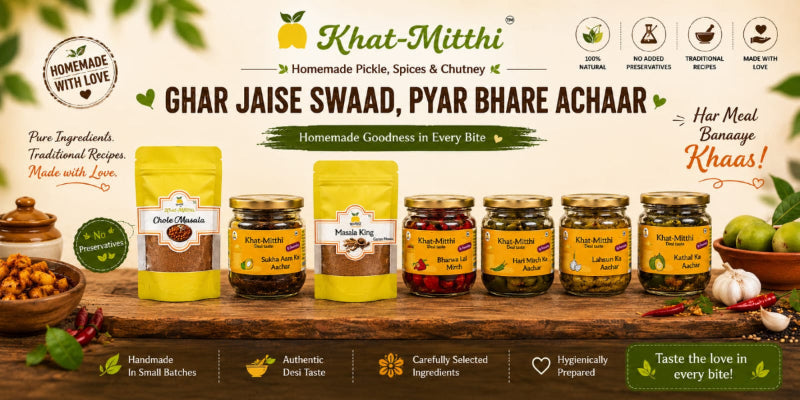 A promotional banner for Khat-Mithi Homemade Pickles, Spices, and Chutney. The banner features multiple packaged products including yellow pouches and glass jars of pickles and chutneys arranged on a rustic wooden table with ingredients like garlic, onions, and green chilies.